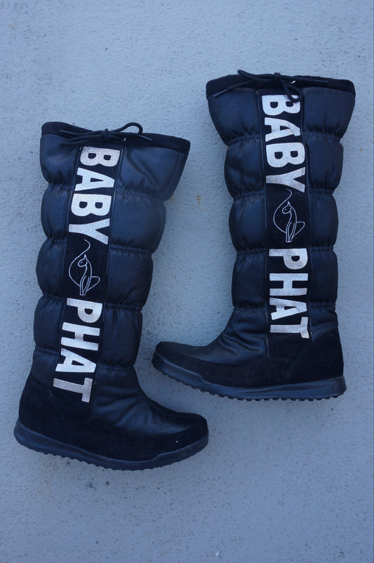 Black boots with 'BABY PHAT' branding on a gray surface