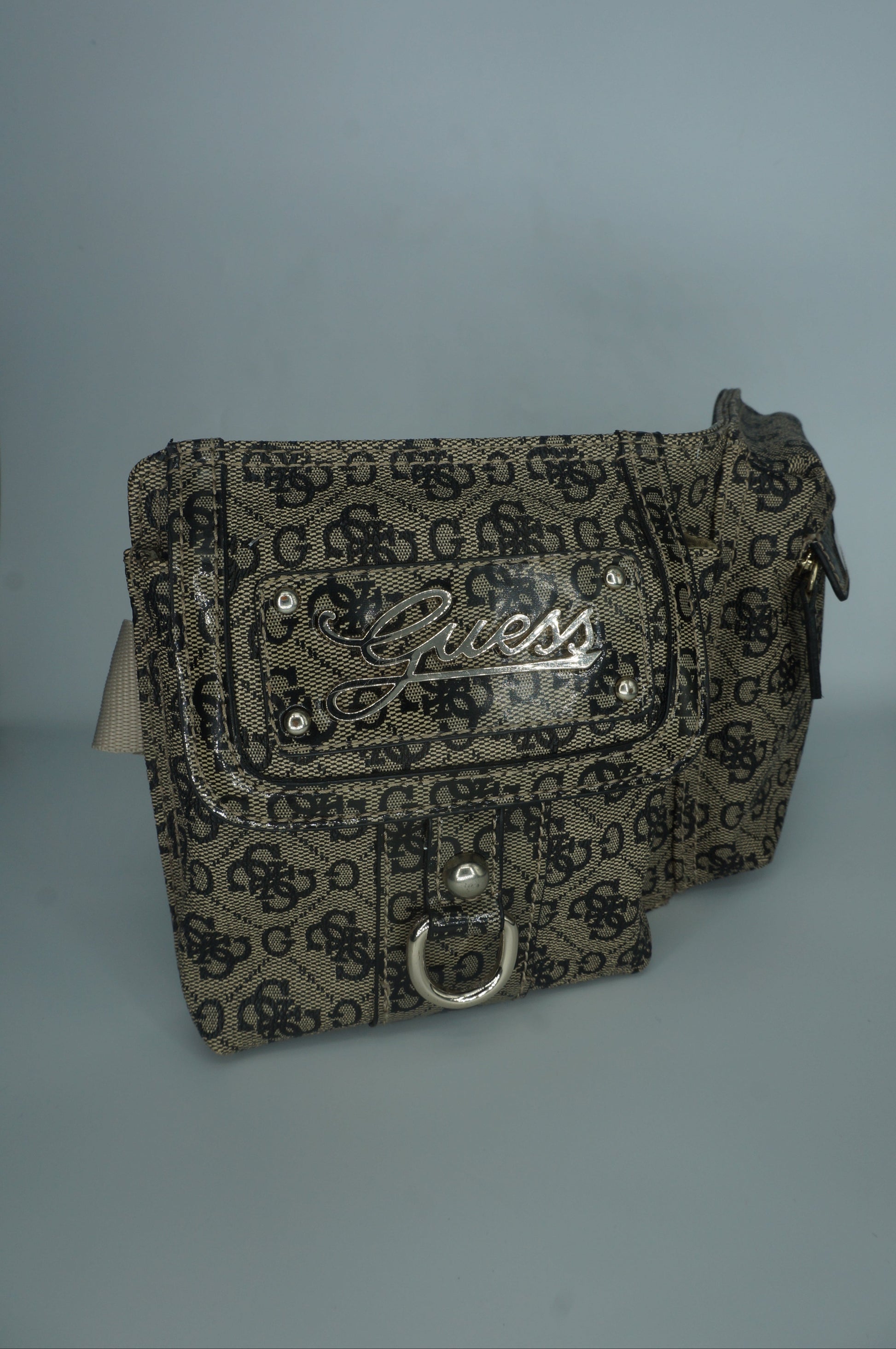 Patterned guess fanny pack with a brand logo on a light gray background